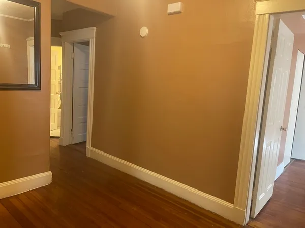 an empty room with wooden floor and entrance