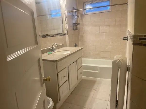 a bathroom with a granite countertop sink a toilet and shower