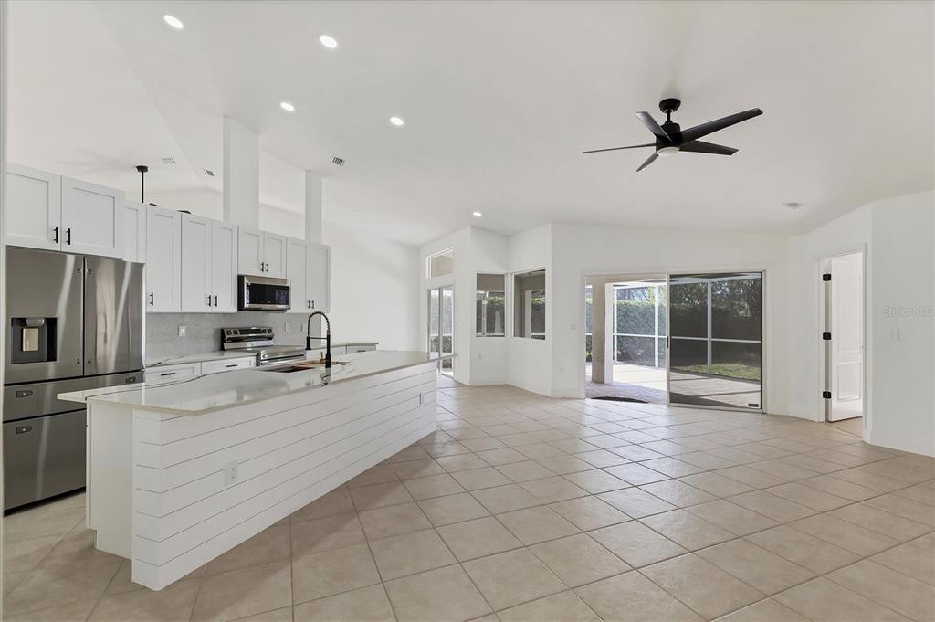 6409 Stone River Road Bradenton, FL 34203 - Photo 15 of 55 a large white kitchen with granite countertop a stove a sink a window and stainless steel appliances
