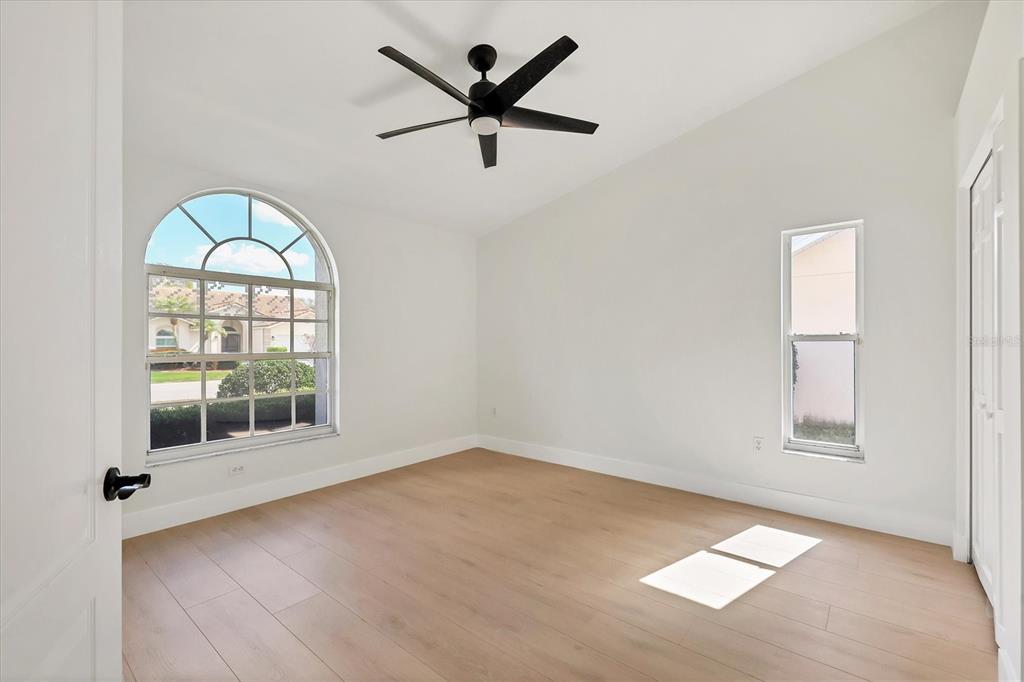 6409 Stone River Road Bradenton, FL 34203 - Photo 22 of 55 an empty room with wooden floor fan and windows