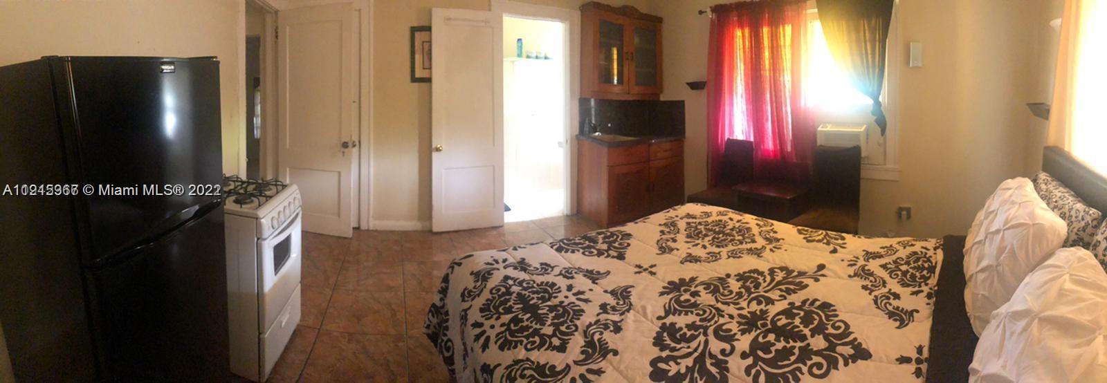 2007 North Bay Road, Unit STUDIO2 Miami Beach, FL 33140 - Photo 2 of 4 a bedroom with a bed and a flat tv screen next to a window