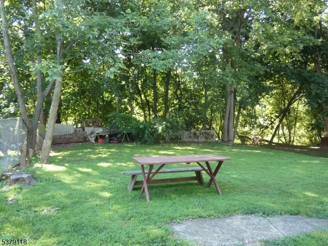 a bench sitting in the grass near a tree