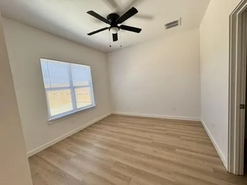 an empty room with a window and a fan