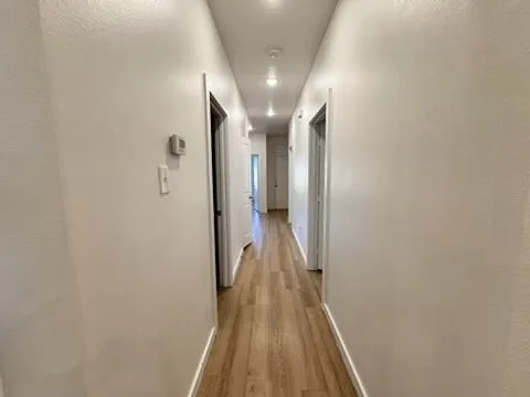 a view of a hallway with wooden floor