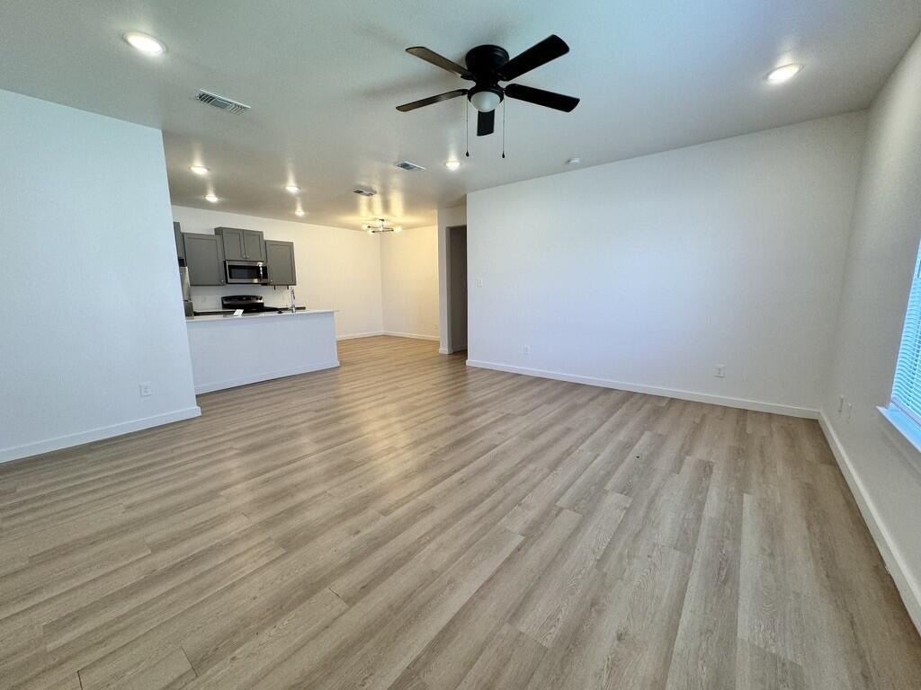 5711 Kemper Street, Unit B Lubbock, TX 79416 - Photo 2 of 20 a view of a kitchen with a sink and wooden floor