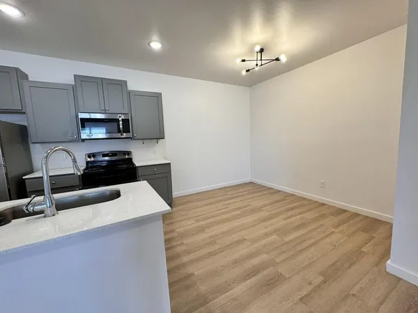 a kitchen with granite countertop a sink and a stove top oven