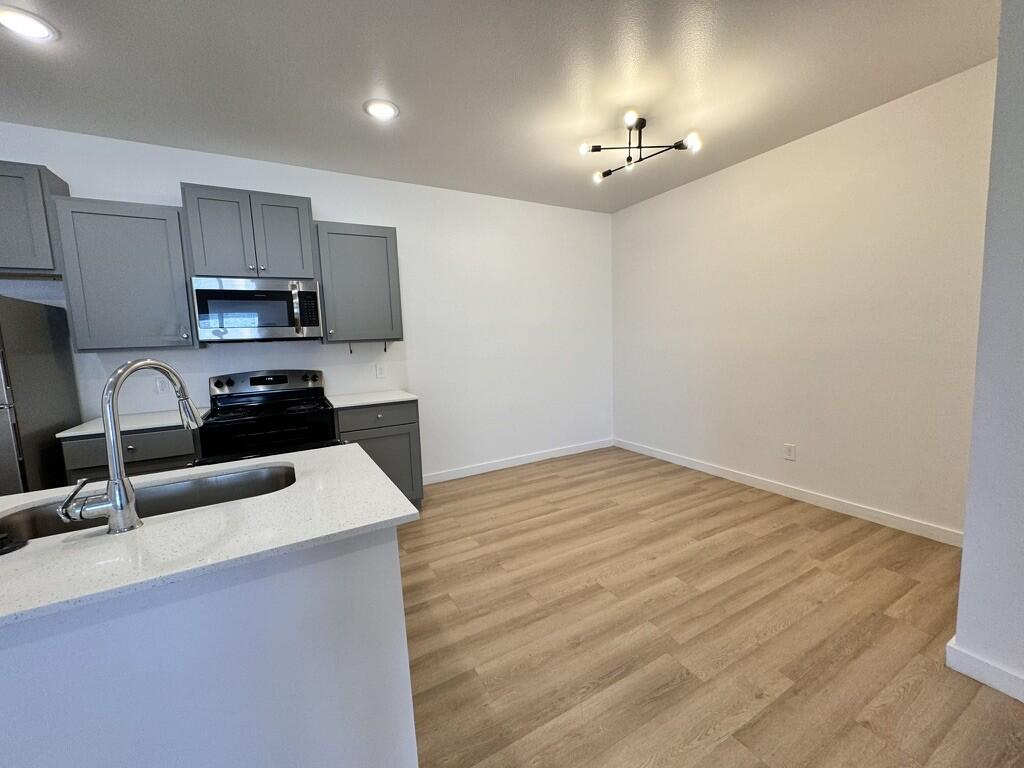 5711 Kemper Street, Unit B Lubbock, TX 79416 - Photo 3 of 20 a kitchen with granite countertop a sink and a stove top oven