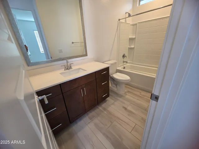 a bathroom with a double vanity sink toilet mirror and shower
