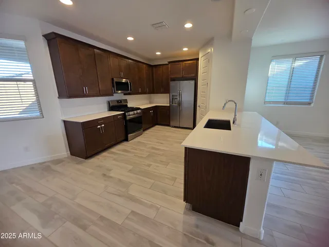 a kitchen with stainless steel appliances wooden cabinets a sink and a stove
