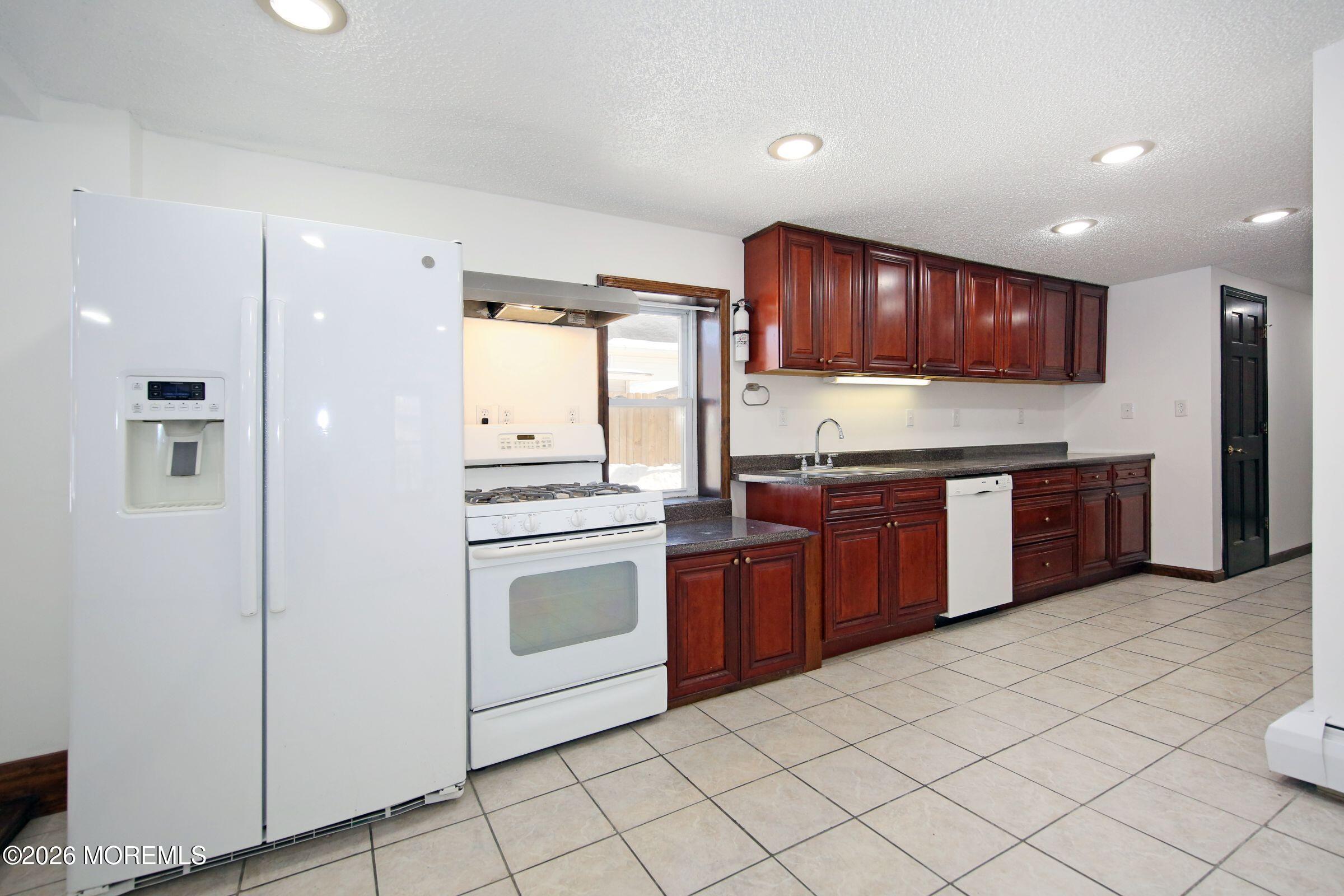 60 Matthew Street, Unit 1 Highlands, NJ 07732 - Photo 9 of 33 a kitchen with stainless steel appliances granite countertop a stove sink and cabinets