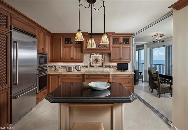a kitchen with stainless steel appliances granite countertop a sink a stove and a refrigerator
