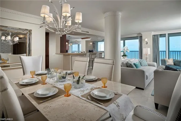 a dining room with furniture a chandelier and wooden floor