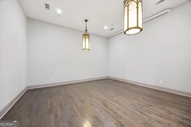 an empty room with wooden floor and window