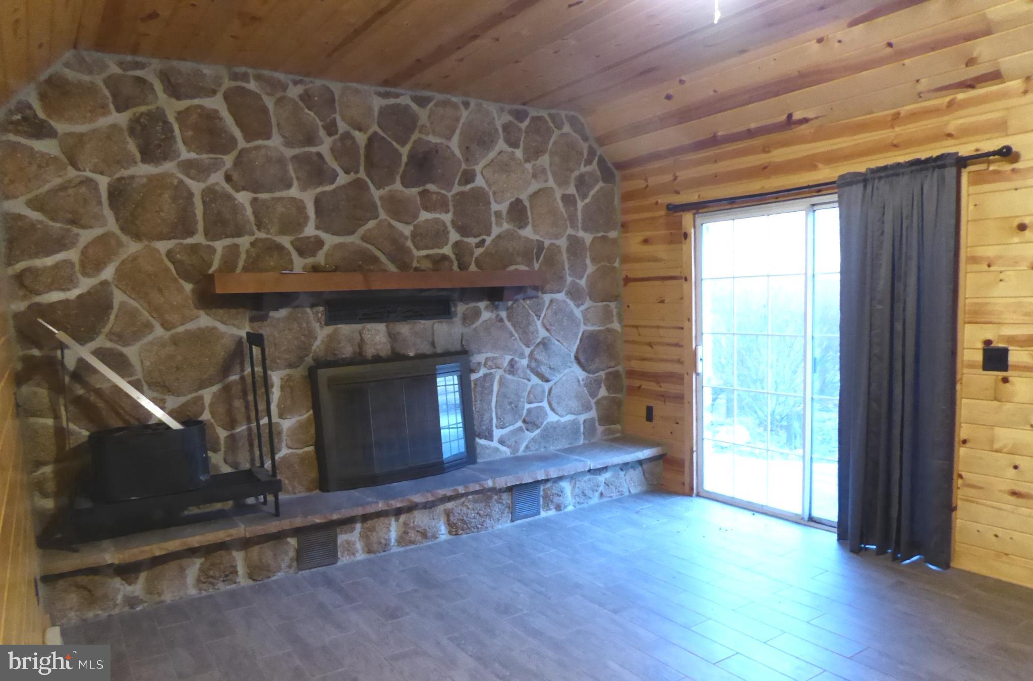 102 Dry Run Road Burlington, WV 26710 - Photo 24 of 85 Cozy stone fireplace in a rustic retreat.