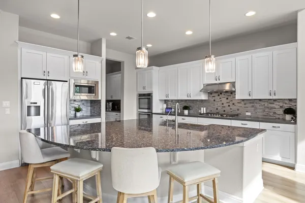 a spacious bathroom with a granite countertop sink a toilet a mirror and shower