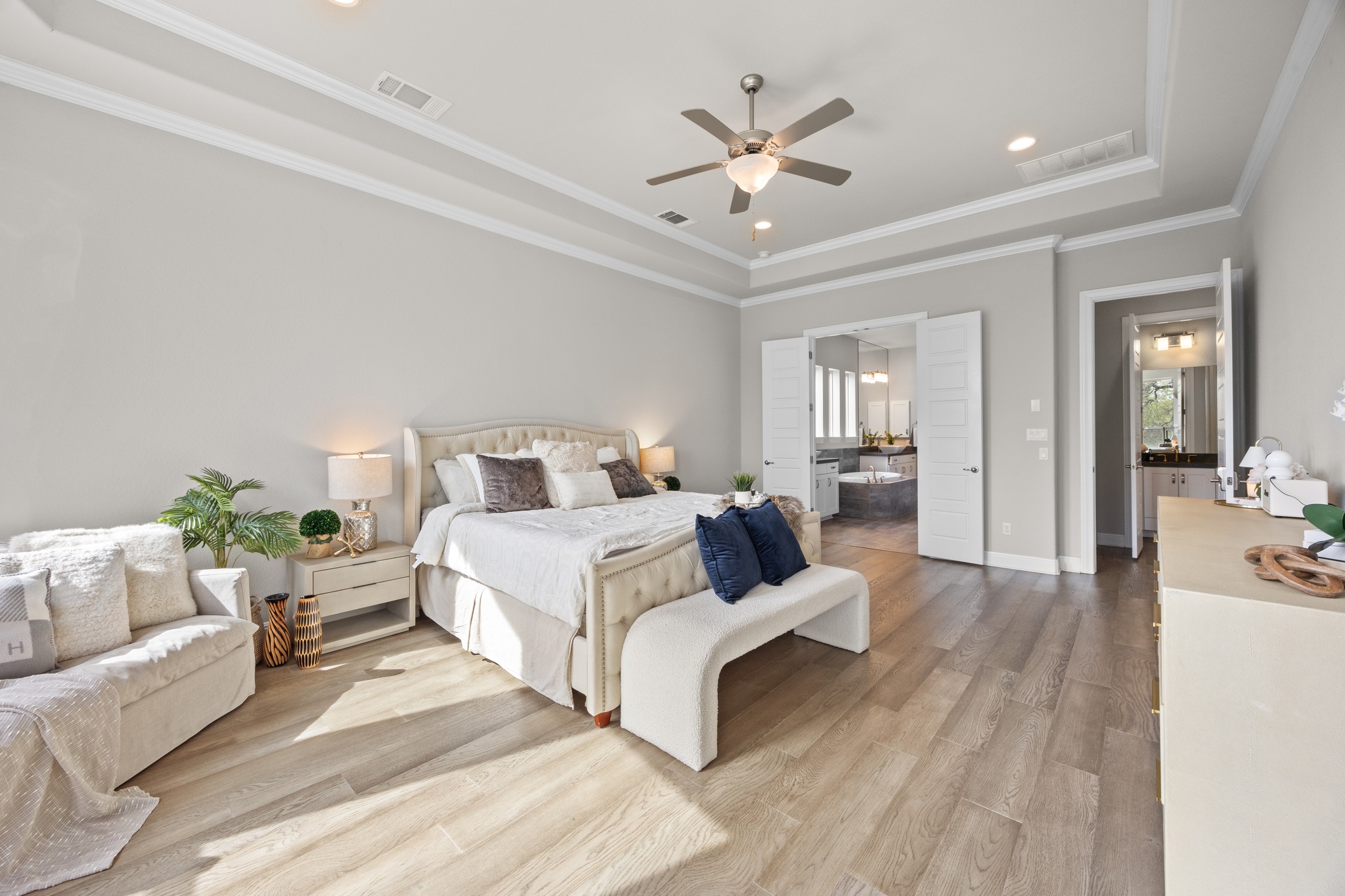 15705 Colinas Cove Bee Cave, TX 78738 - Photo 19 of 40 a bedroom with a large bed and ceiling fan