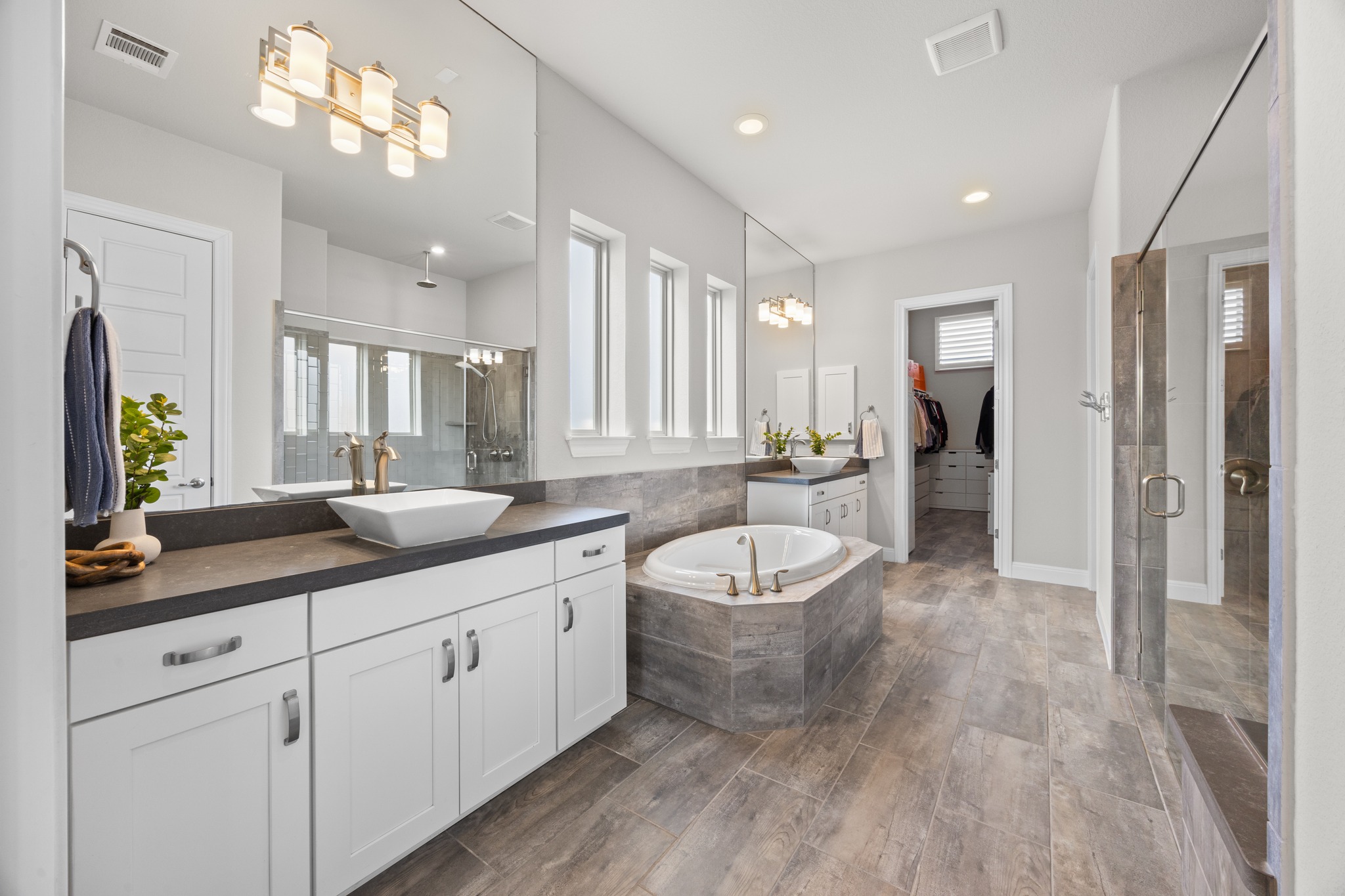 15705 Colinas Cove Bee Cave, TX 78738 - Photo 20 of 40 a spacious bathroom with a granite countertop sink a toilet a mirror and shower