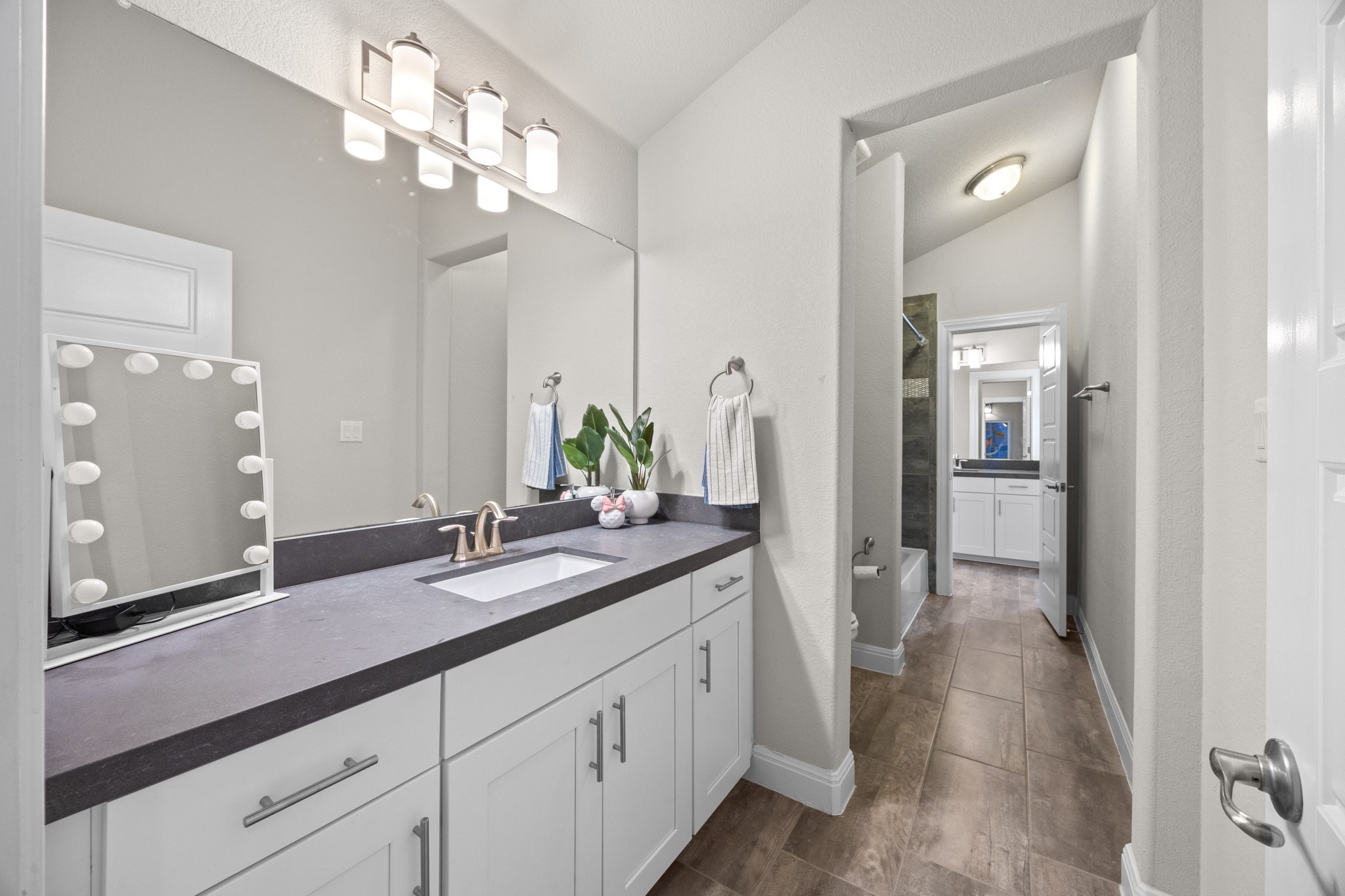 15705 Colinas Cove Bee Cave, TX 78738 - Photo 29 of 40 a spacious bathroom with a granite countertop sink a mirror and a shower