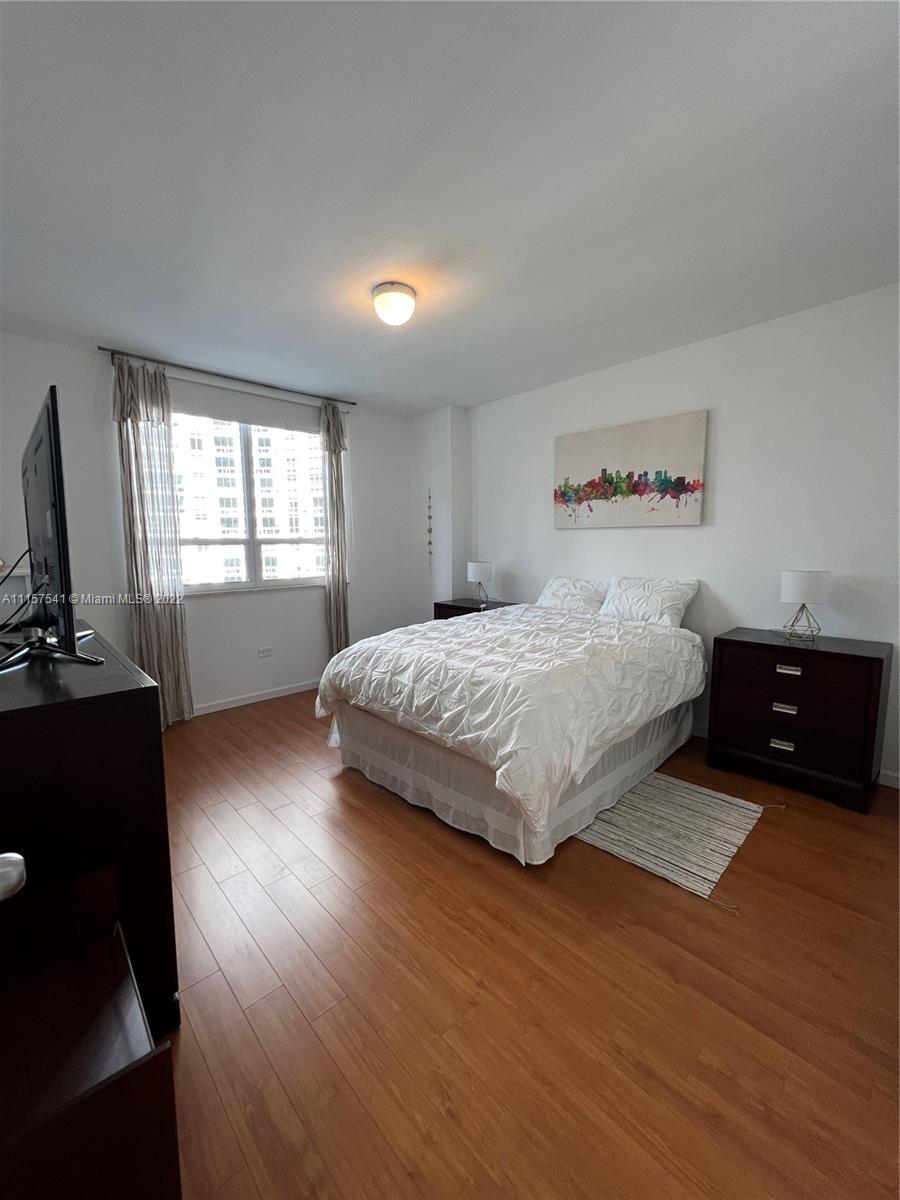 801 Brickell Key Boulevard, Unit 1506 Miami, FL 33131 - Photo 12 of 27 a bedroom with a bed and wooden floor