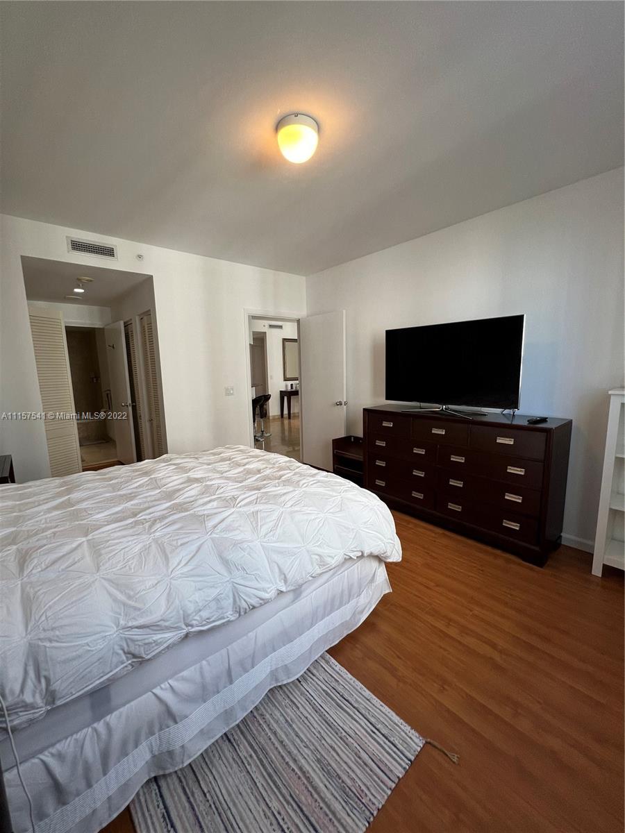 801 Brickell Key Boulevard, Unit 1506 Miami, FL 33131 - Photo 13 of 27 a large bedroom with a bed and a flat screen tv