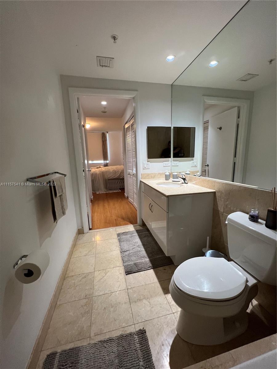 801 Brickell Key Boulevard, Unit 1506 Miami, FL 33131 - Photo 18 of 27 a bathroom with a toilet a sink a mirror and shower