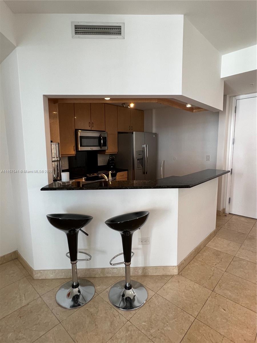 801 Brickell Key Boulevard, Unit 1506 Miami, FL 33131 - Photo 9 of 27 a living room with furniture and a chandelier