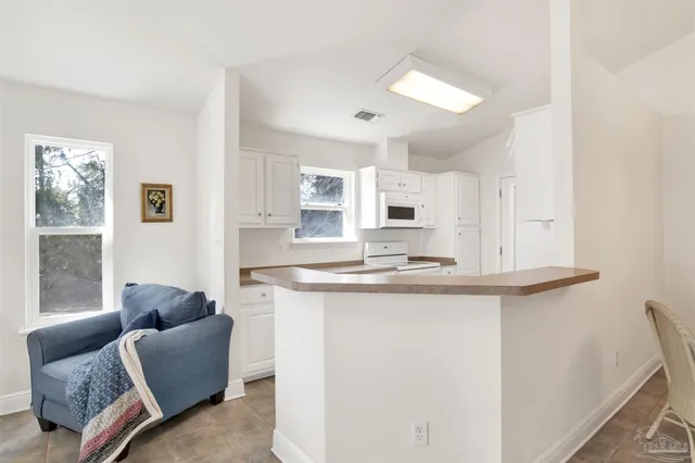 a kitchen with granite countertop white cabinets and white appliances