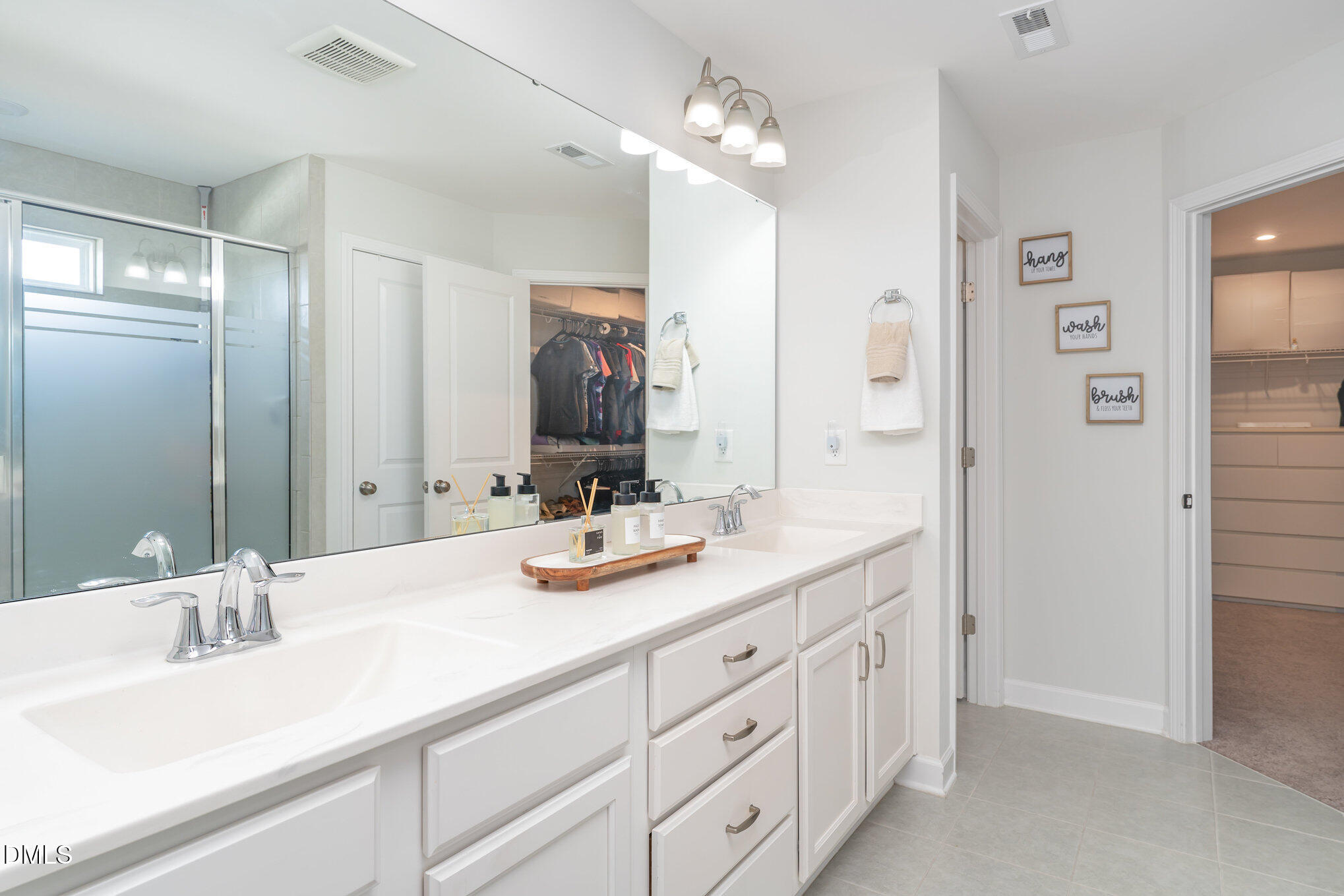 73 Lockhaven Drive Garner, NC 27529 - Photo 19 of 38 a bathroom with double vanity sinks a vanity a lamp and a mirror