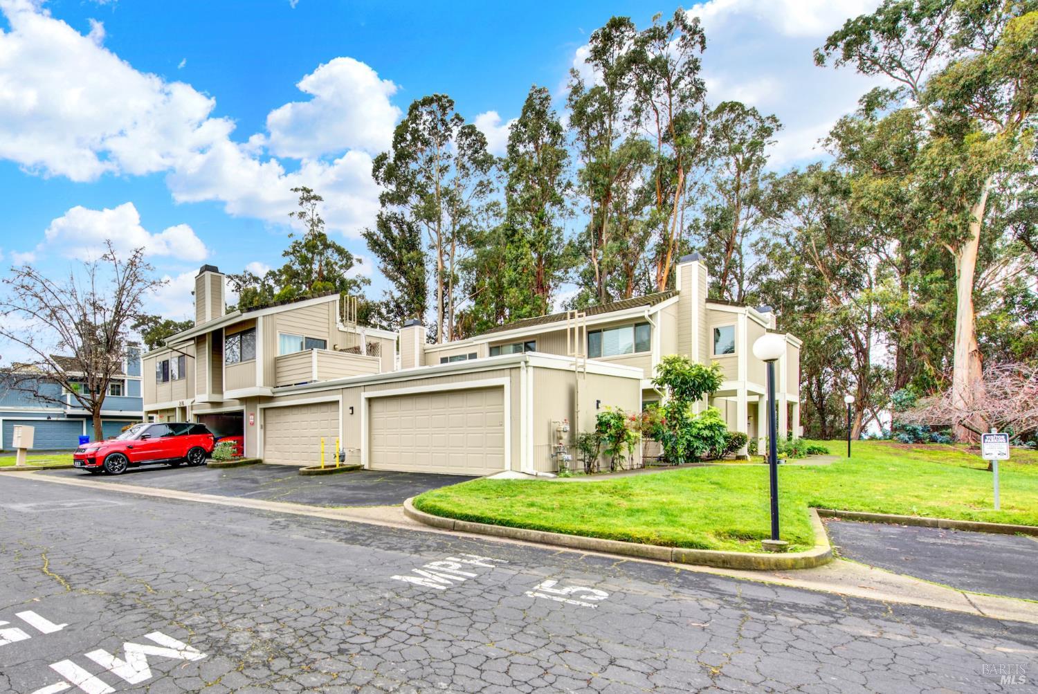 216 Apollo, Unit 7 Hercules, CA 94547 - Photo 3 of 29 a view of a white house with a big yard and large trees