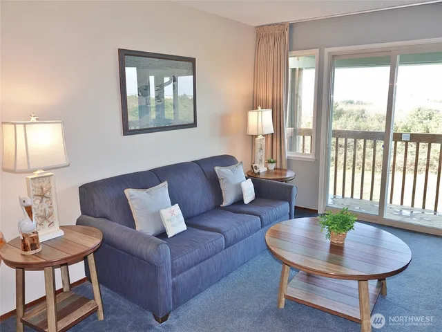 a living room with furniture a chandelier and wooden floor