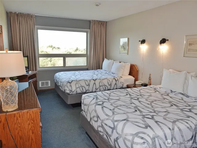 a bedroom with a large bed and a flat tv screen on dresser