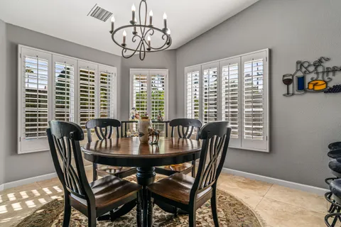 a dining room with furniture a chandelier and window