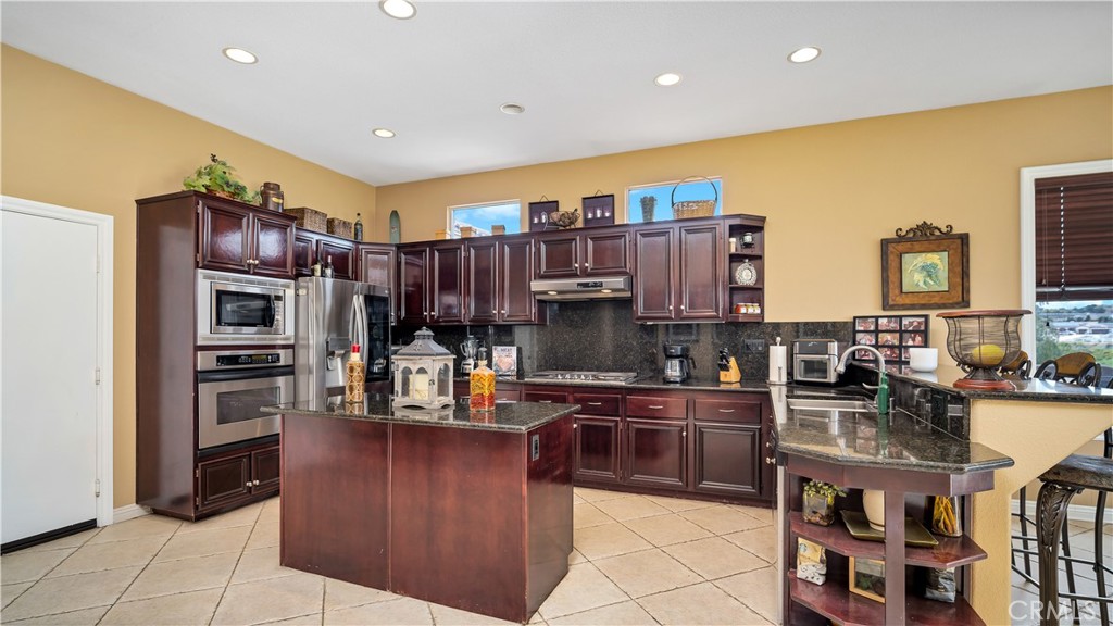 23894 Trail Duster Court Perris, CA 92570 - Photo 18 of 75 a kitchen with stainless steel appliances granite countertop a refrigerator and a stove top oven