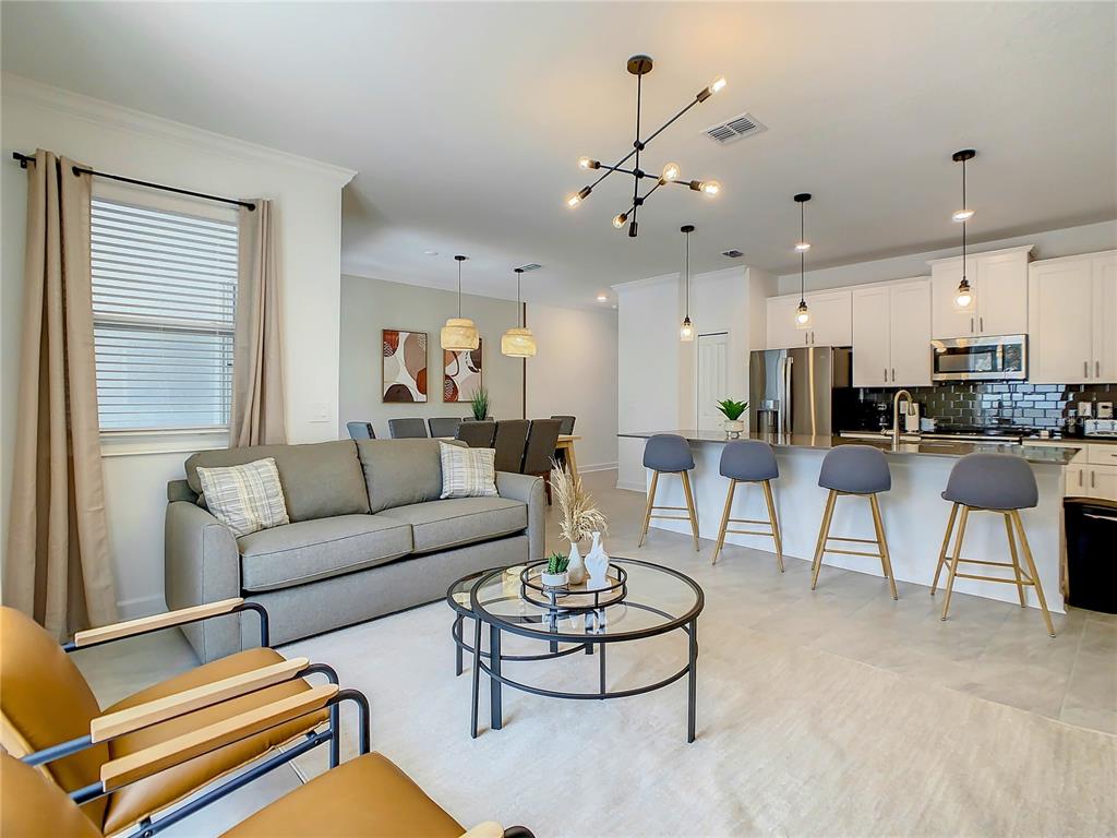 2573 Reading Trail Kissimmee, FL 34746 - Photo 20 of 54 a living room with furniture kitchen and a chandelier
