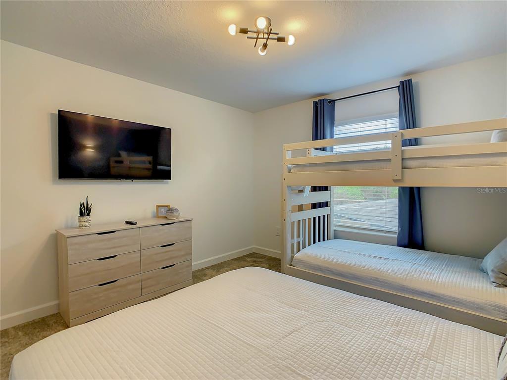 2573 Reading Trail Kissimmee, FL 34746 - Photo 23 of 54 a bedroom with a bed and a flat screen tv