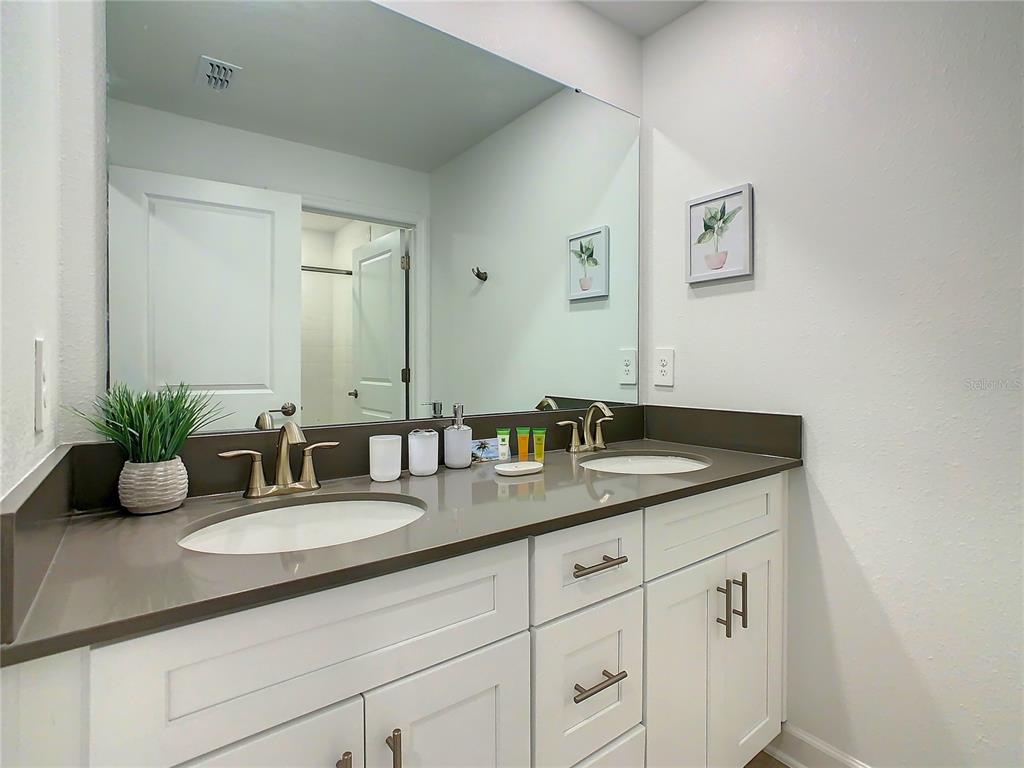 2573 Reading Trail Kissimmee, FL 34746 - Photo 29 of 54 a bathroom with a granite countertop sink and a mirror