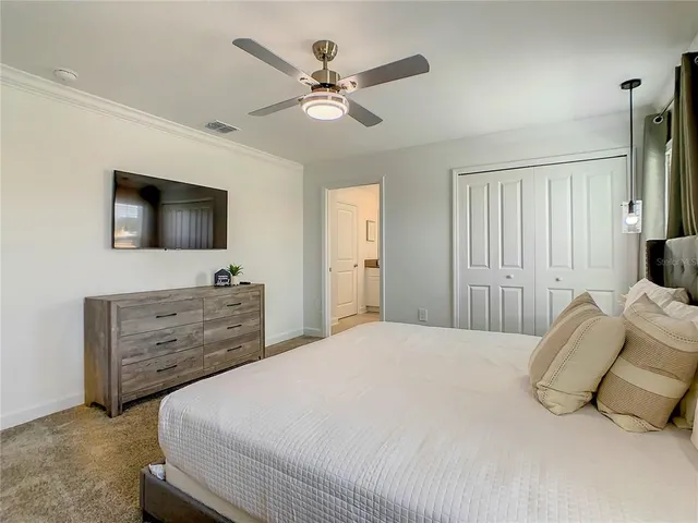 a bedroom with a large bed and a flat screen tv
