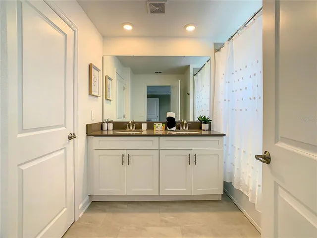 a bathroom with a granite countertop sink mirror toilet and bathtub