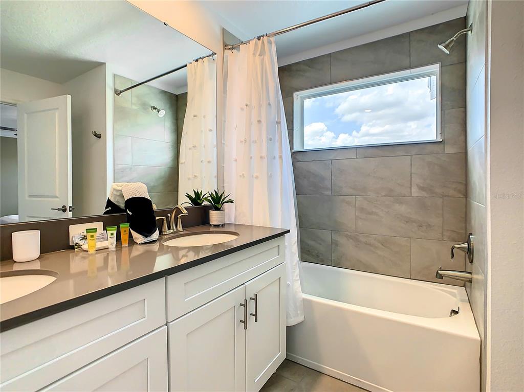 2573 Reading Trail Kissimmee, FL 34746 - Photo 35 of 54 a bathroom with a granite countertop sink mirror toilet and bathtub