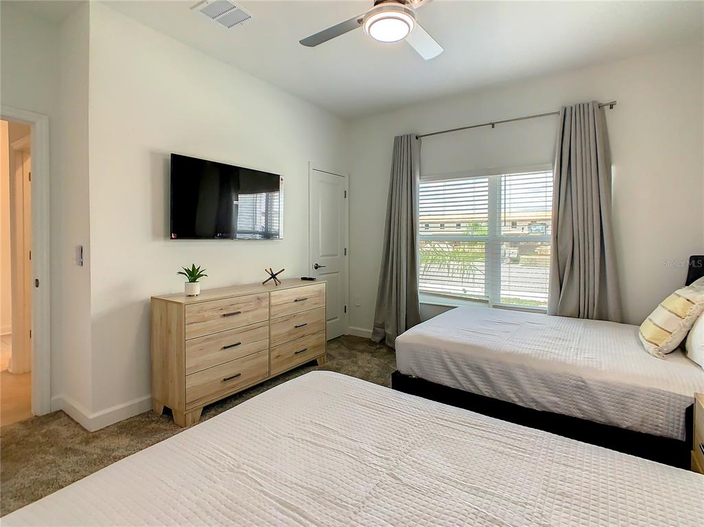 2573 Reading Trail Kissimmee, FL 34746 - Photo 37 of 54 a bedroom with a large bed and a flat screen tv