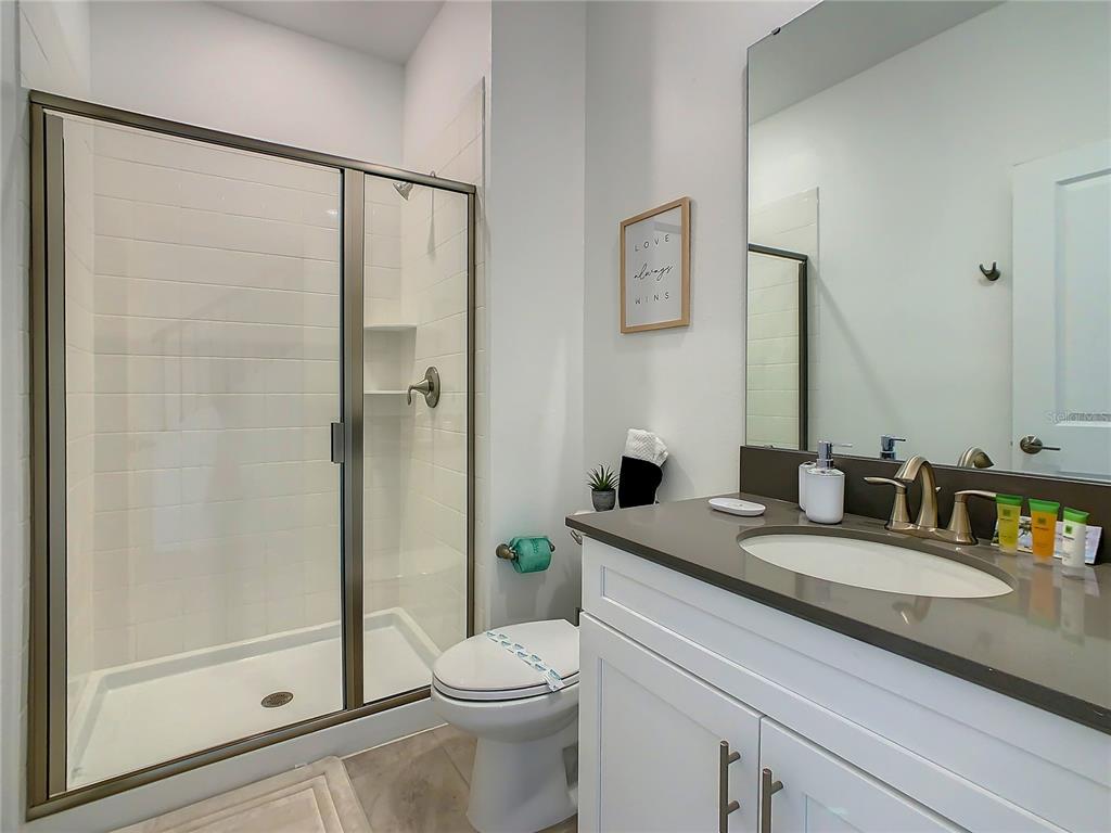2573 Reading Trail Kissimmee, FL 34746 - Photo 40 of 54 a bathroom with a granite countertop sink toilet and shower