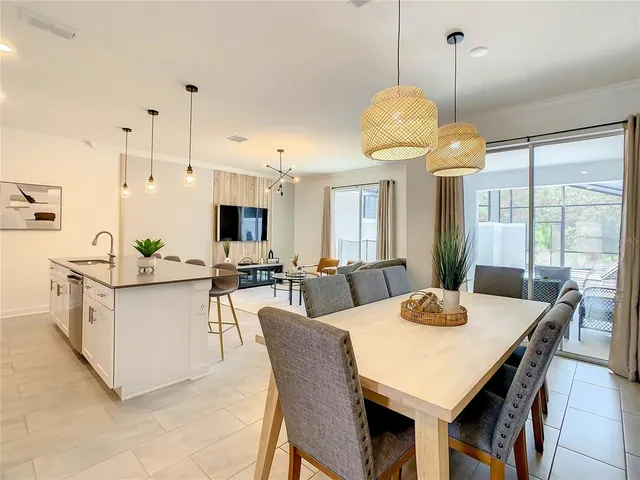 a view of a dining room and livingroom with furniture wooden floor and a chandelier