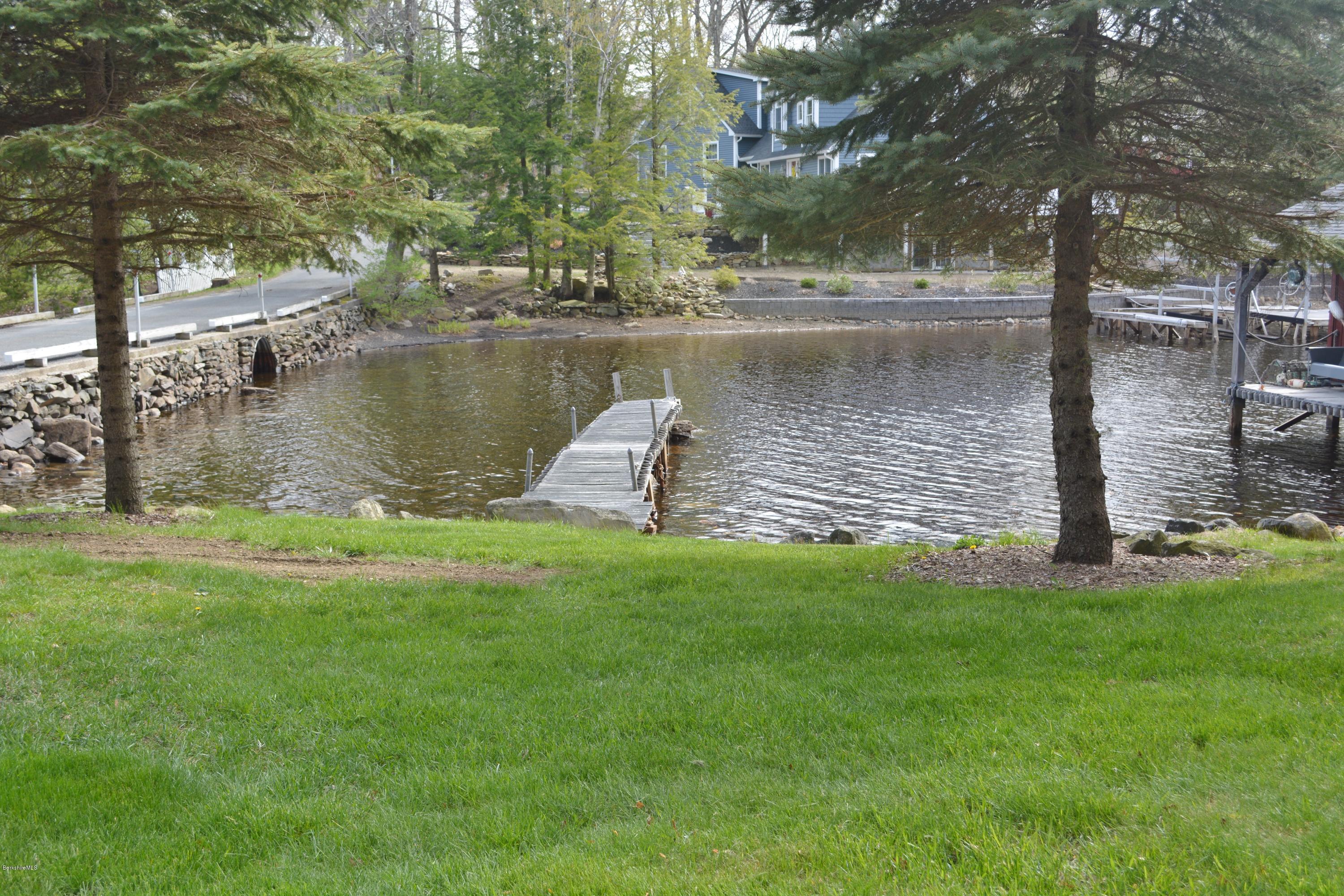99 Kibbe Road Otis, MA 01029 - Photo 14 of 58 a view of a lake with a yard and large trees