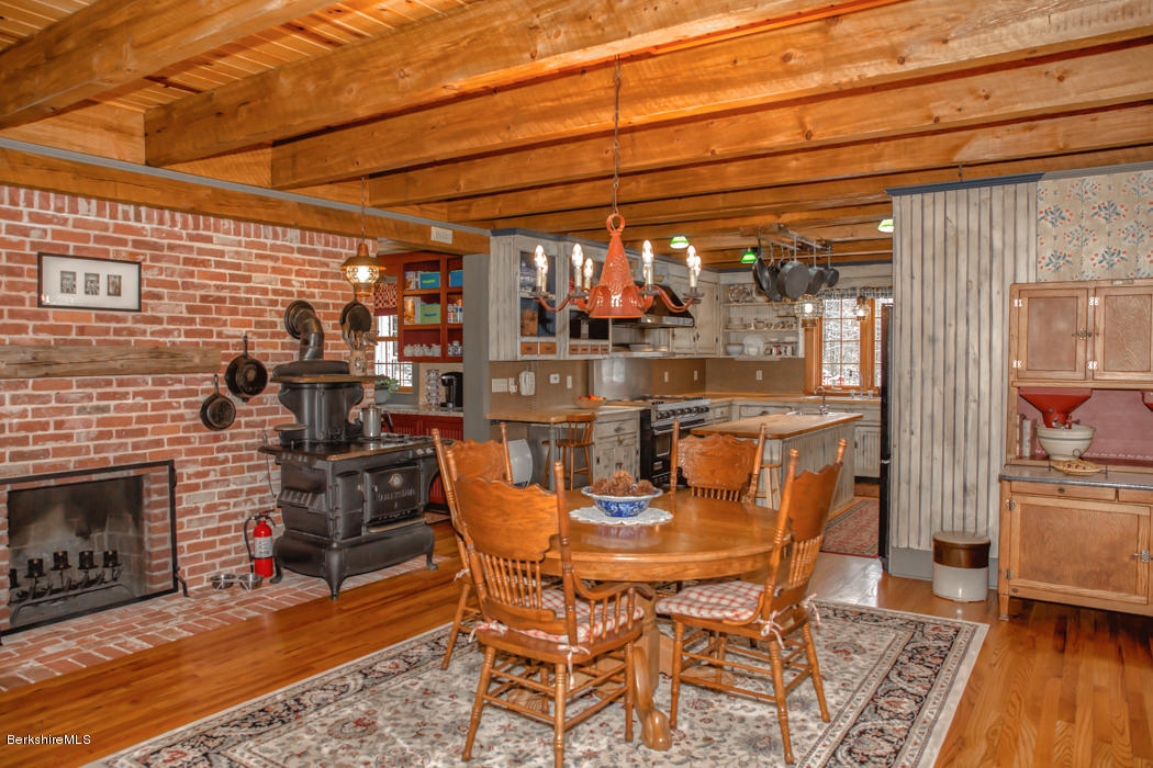 99 Kibbe Road Otis, MA 01029 - Photo 19 of 58 a dining room with furniture and a fireplace