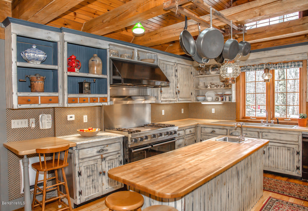 99 Kibbe Road Otis, MA 01029 - Photo 22 of 58 a kitchen with stainless steel appliances a stove a sink dishwasher and cabinets with wooden floor