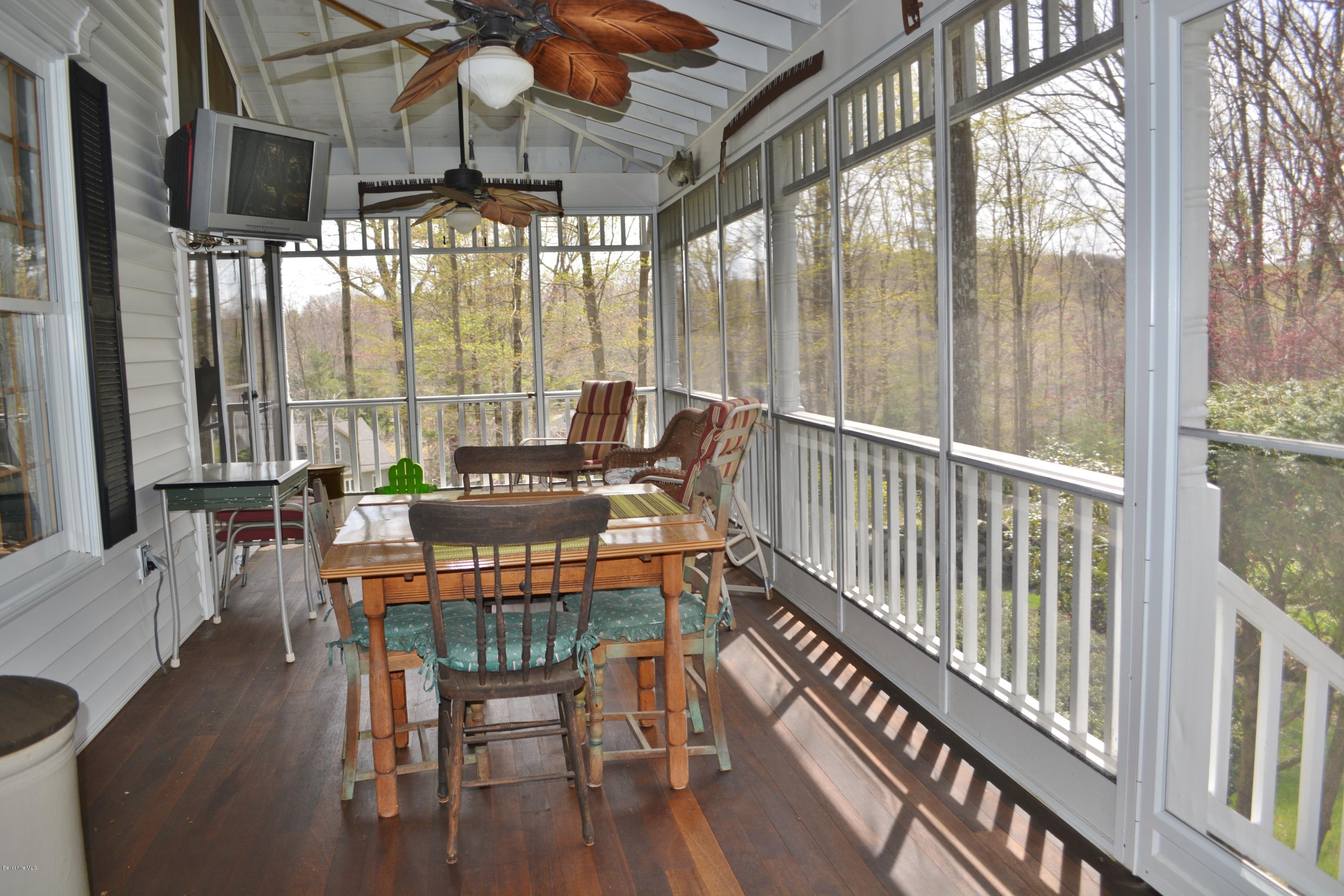 99 Kibbe Road Otis, MA 01029 - Photo 29 of 58 a dining room with furniture wooden floor and a chandelier
