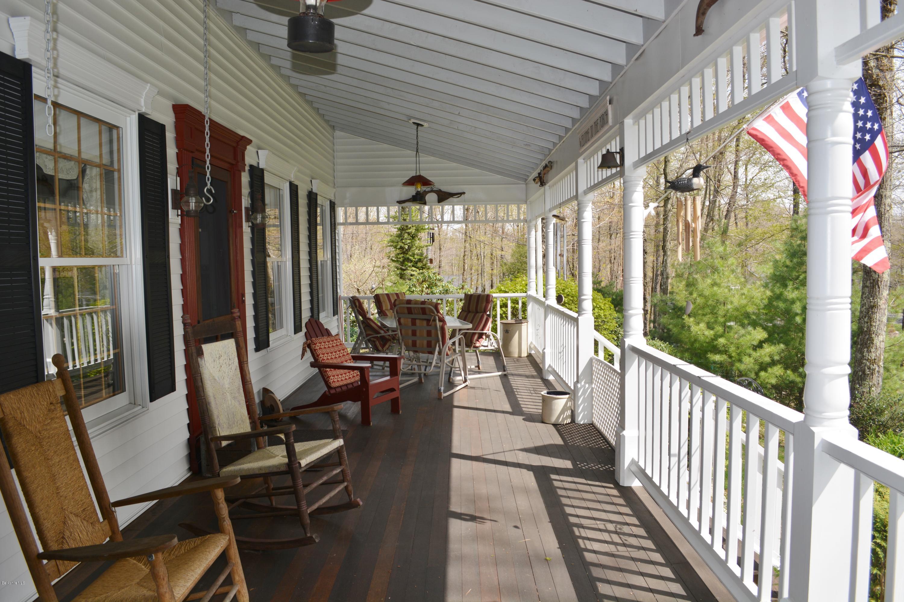 99 Kibbe Road Otis, MA 01029 - Photo 30 of 58 a view of a patio with chairs and floor to ceiling window