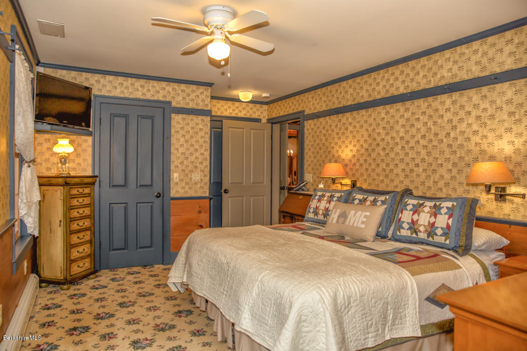 99 Kibbe Road Otis, MA 01029 - Photo 31 of 58 a bedroom with a bed and a chandelier