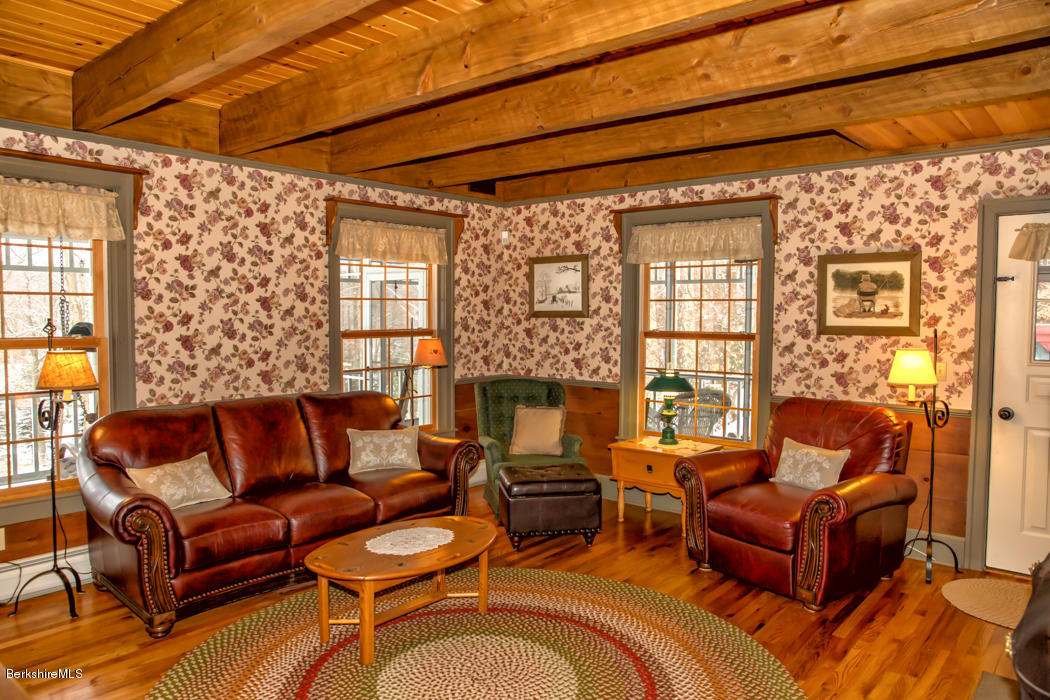 99 Kibbe Road Otis, MA 01029 - Photo 38 of 58 a living room with furniture a large window and a fireplace