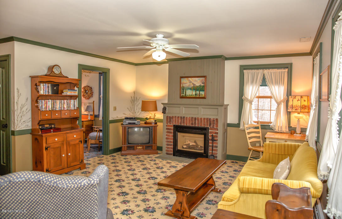 99 Kibbe Road Otis, MA 01029 - Photo 45 of 58 a living room with furniture a fireplace and a flat screen tv